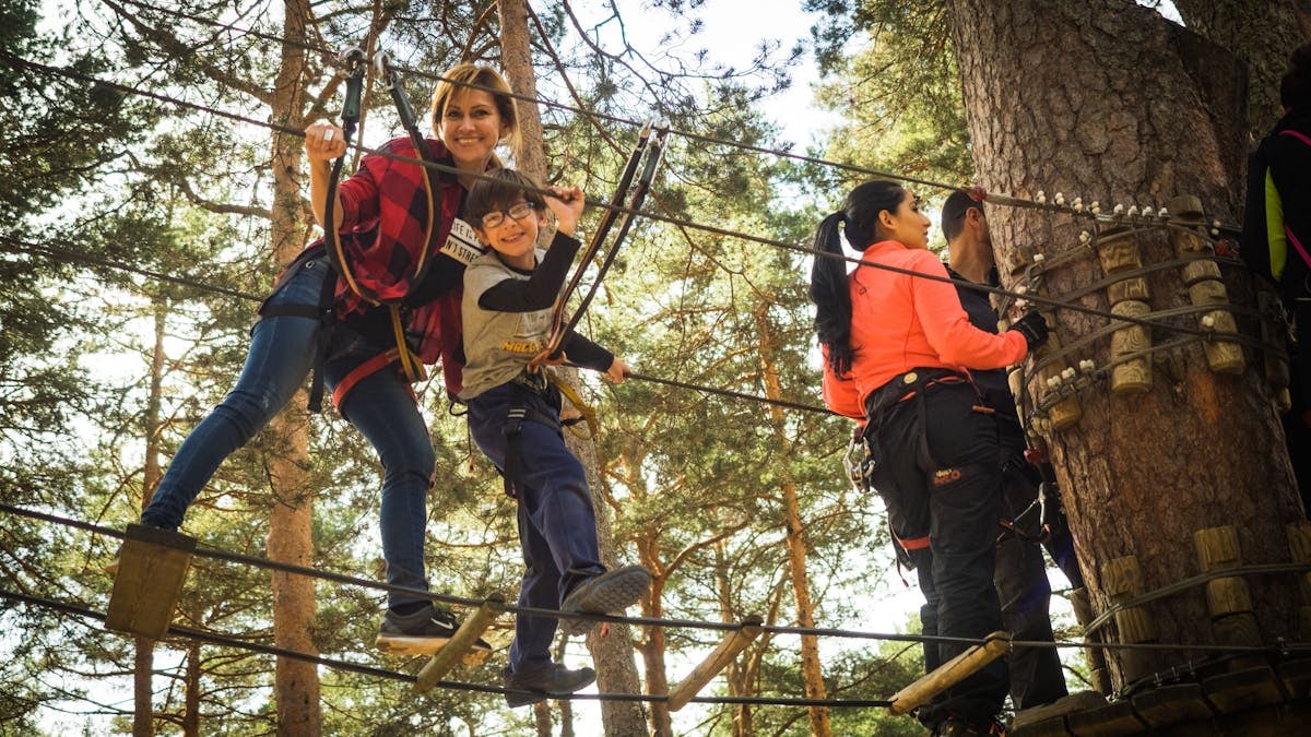 A family enjoys a thrilling day on a ropes course in Cercedilla, Spain.